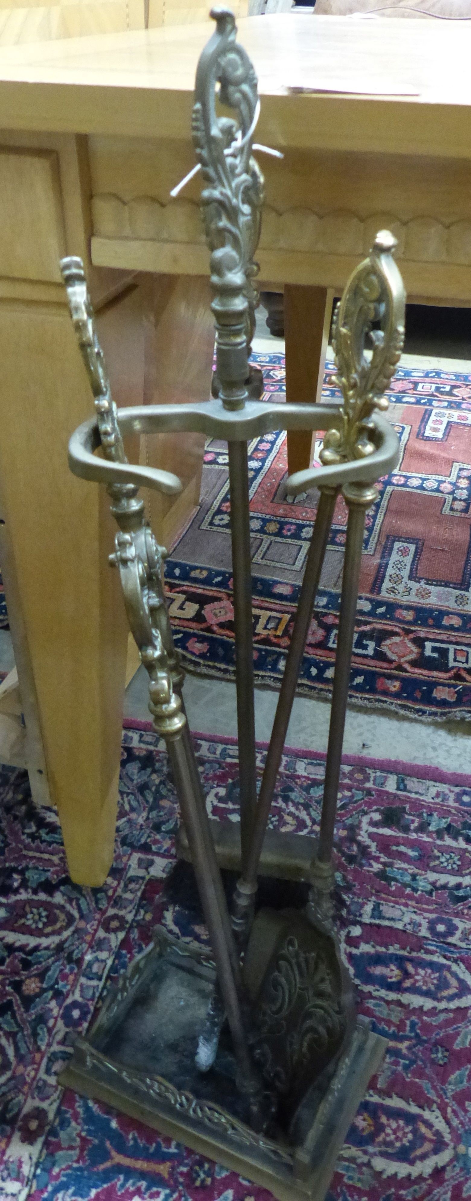 A pair of three Louis XV style brass fire implements and matching stand